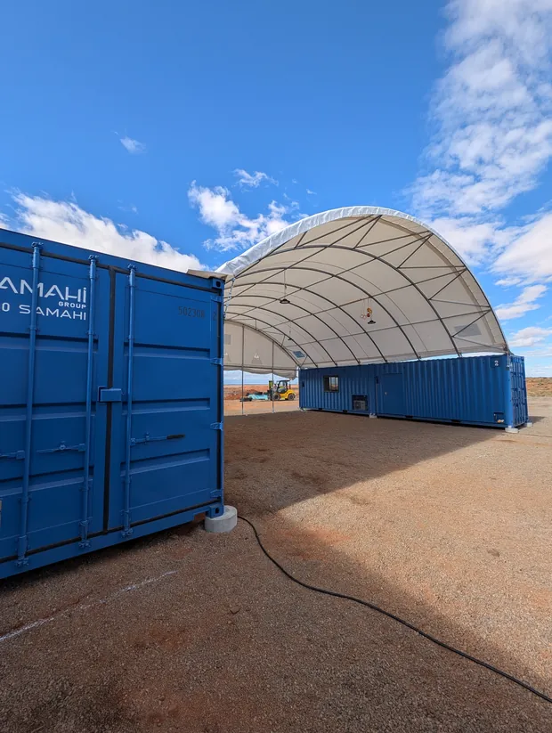 Dome shelter workshop installed between the container line at the Cue site